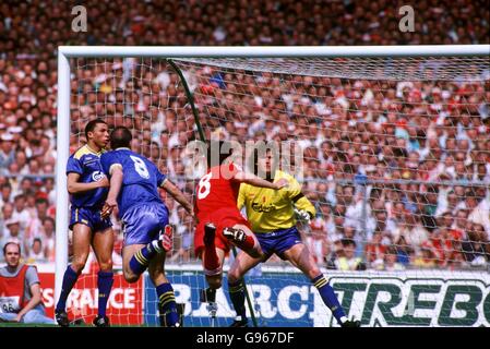 Liverpools John Aldridge (zweiter rechts) taucht ein, um einen Kopfball in Richtung Tor zu lenken, während Wimbledons Terry Phelan (links), Alan Cork (zweiter links) und Dave Beasant (rechts) darauf schauen Stockfoto