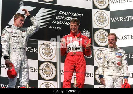 Ferrari's Michael Schumacher (Mitte) feiert seinen Sieg, als David Coulthard (links) und Rubens Barrichello (rechts) auf ihn schauen Stockfoto