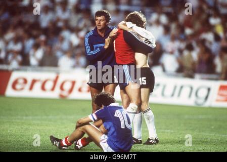 Der Westdeutsche Torhüter Harald Schumacher (Mitte) feiert mit Teamkollege Uli Stielike (rechts) nach der Rettung der lebenswichtigen Strafe im Schießen, um die Bundesrepublik ins Finale zu holen. Frankreichs Michel Platini ist im Vordergrund untröstlich Stockfoto