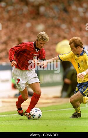 Der Engländer David Beckham (links) tritt gegen den Schweden Fredrik Ljungberg (rechts) an Stockfoto