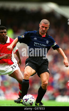 Fußball - FA Carling Premiership - Arsenal / Manchester United. Nwankwo Kanu von Arsenal (links) sieht zu, wie Roy Keane von Manchester United (rechts) den Ball passiert Stockfoto