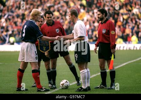 Fußball - Euro 2000 Qualifikation - Play Off First Leg - Schottland gegen England. Schiedsrichter Manuel Diaz Vega (Mitte) sieht zu, wie der schottische Kapitän Colin Hendry (links) mit seiner Gegenzahl Alan Shearer (rechts) die Hände schüttelt Stockfoto