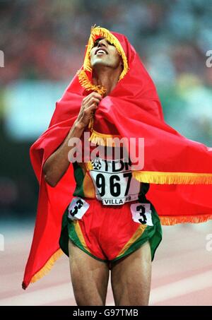 Der Marokkaner Hicham El Guerrouj feiert den Sieg des 1500-M-Wettkampfs der Männer Mit der Flagge seines Landes Stockfoto