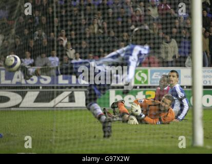 Pascal Chimbonda von Wigan Athletic erzielt in der letzten Spielminute ein eigenes Tor, während Louis Saha von Manchester United mit Wigan-Torwart John Filan und Paul Scharner zuschaut Stockfoto