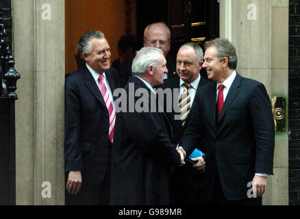 Der Premierminister Tony Blair schüttelt die Hand des irischen Taoiseach, Bertie Ahern, als der irische Außenminister Dermot Ahern (2. Rechts), Der irische Justizminister Michael McDowell (Mitte-hinten) und der nordirische Staatssekretär Peter Hain (links) blicken von den Stufen der Downing Street Nr. 10 im Zentrum Londons aus auf die Straße. Stockfoto