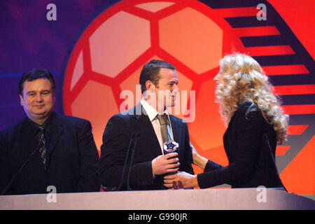 Manchester United und Wayne Rooney aus England erhalten den Young Player of the Year Award der FIFPro Academy von Jerry Hall (r), als Eamonn Holmes (l) anschaut.bei den Mastercard FIFPro World XI Player Awards 2005, die für Sky One aufgenommen wurden. Stockfoto