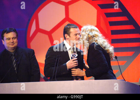 Manchester United und Wayne Rooney aus England erhalten den Young Player of the Year Award der FIFPro Academy von Jerry Hall (r), als Eamonn Holmes (l) anschaut.bei den Mastercard FIFPro World XI Player Awards 2005, die für Sky One aufgenommen wurden. Stockfoto