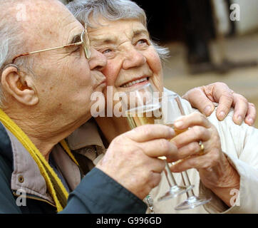 Das Diamant-Ehepaar Bill Cullington 81 und Peggy Cullington 84 trinken ein Glas Champagner, nachdem es am Mittwoch, den 5. April 2006, vom Schmiedeführer Jim Henderson gesegnet wurde. 25 Paare, die ihre Diamant- und Goldenen Hochzeitstage feierten, reisten nach Gretna Green, um sich im weltberühmten Old Blacksmiths Shop über den originalen Amboss segnen zu lassen, zwischen denen sie 1250 Jahre Eheleben bilden. Siehe PA Geschichte SOCIAL Gretna. DRÜCKEN SIE VERBANDSFOTO. DER BILDNACHWEIS SOLLTE DANNY Lawson /PA LAUTEN Stockfoto