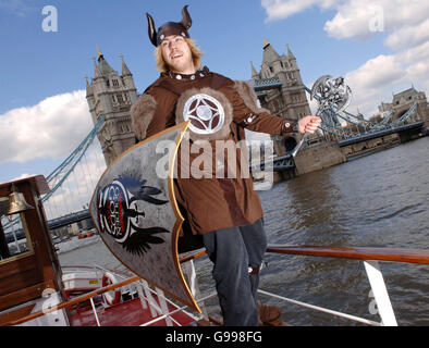 Iain Mackenzie, ein Musiker, macht sich auf einem authentischen, originalgetreuen Wikinger-Langboot auf den Weg über die Themse, vorbei an der Tower Bridge, in Butler's Wharf in Bermondsey im Südosten Londons. Stockfoto