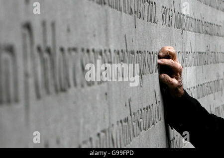 Vater Joseph Mallin, ein Sohn von Michael Mallin eines der führenden 1916 berührt die Memorial Wall um die 1916 Handlung während der jährlichen 1916 Ostern Gedenkfeier Messe am Arbour Hill Church in Dublin. Stockfoto