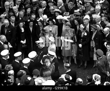 Prinzessin Elizabeth und Lieutenant Philip Mountbatten werden von König George VI begleitet, während sie durch die Versammlung der Gäste auf dem Rasen des Buckingham Palace gehen. Stockfoto
