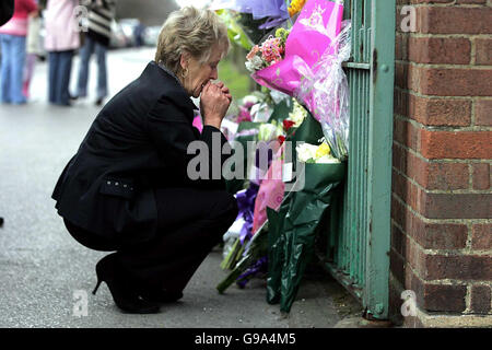 Ein nicht identifizierter Verwandter sieht sich Blumenverehrungen an, die in der Nähe des Mordes an Cheryl Moss auf dem Gelände des St. George's Hospital, Hornchurch in Essex, am Freitag, dem 7. April 2006, platziert wurden. Zusätzliches Sicherheitspersonal ist im Krankenhaus im Einsatz, in dem Cheryl Moss, 33, gestern Morgen bei einer Zigarettenpause am Vormittag getötet wurde. Siehe PA Story POLICE Nurse. Stockfoto