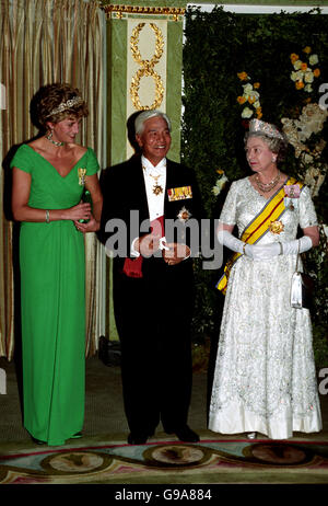 Diana, Prinzessin von Wales, trägt ein langes Abendkleid von smaragdgrün von Catherine Walker, mit seiner Majestät dem Yang Di Pertuan Agong (C) und der Königin (R). Stockfoto