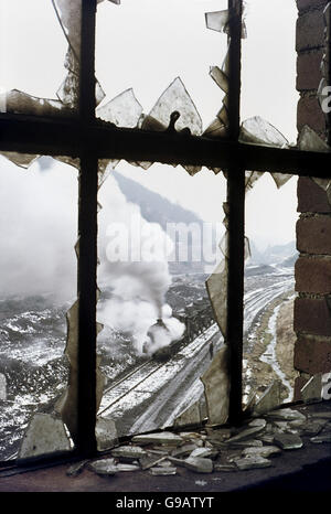 Eine strenge Hunslet macht seinen Weg durch das Tal am Hafod Zeche mit einem Rechen der Wagen von der Schiefer-Spitze. Ein Herbst Schnee Stockfoto
