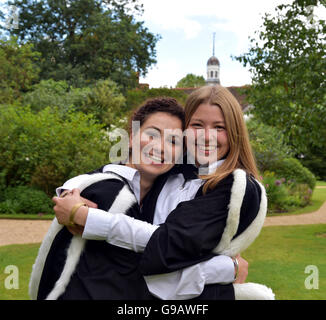 Lächelnd Schüler feiert ihren Abschluss an der Universität Cambridge, tragen ihre Fell gefütterte Kapuze und Kleider auf dem Rasen Stockfoto