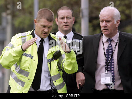 Harry Stephenson (rechts), der Superintendant der Polizei von Durham, wird von einem Verkehrspolizisten erzählt, was am Tatort in der Horsley Hill Road in South Shields geschah, nachdem eine Mutter und ihre beiden kleinen Kinder schwer verletzt wurden und ihre Großmutter getötet wurde, nachdem sie beim Überqueren mit einem Auto zusammengestoßen war Straße. Stockfoto