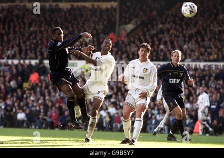 (l-r) Wimbledon's Robbie Earle bekommt in einem Kopf trotz der Aufmerksamkeit von Lucas Radebe und Ian harte von Leeds United Stockfoto