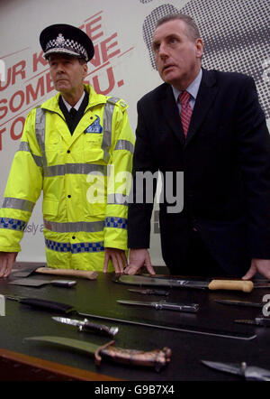 Der Innenminister Vernon Coker und der leitende Beamter Ian Johnston (links) von der Association of Chief Police Officers bei der Enthüllung einer Plakatkampagne zum Beginn der ersten landesweiten Messeramnestie seit 10 Jahren auf der Polizeiwache St. John's Wood im Norden Londons. Stockfoto