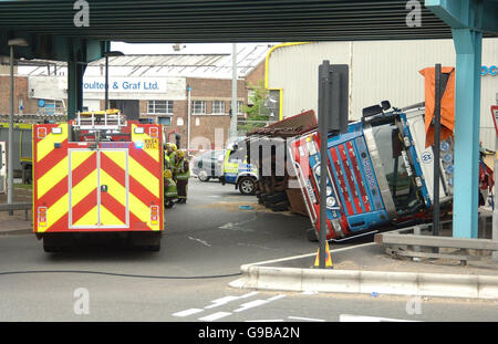 Ein LKW liegt auf der Seite nach einem Verkehrsunfall am Ripple Straße Kreisverkehr unterhalb der A13 in Dagenham, Essex. Stockfoto