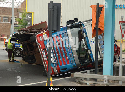 Ein LKW liegt auf der Seite nach einem Verkehrsunfall am Ripple Straße Kreisverkehr unterhalb der A13 in Dagenham, Essex. Stockfoto