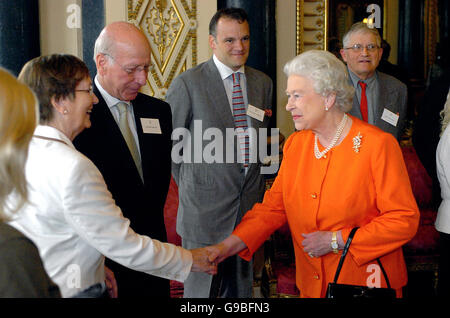 Queen Elizabeth II trifft Sir Bobby Charlton CBE und seine Frau Lady Charlton (2. Links) im Blue Drawing Room des Buckingham Palace während eines Empfangs für die „Serving Beyond Sixty“. Stockfoto