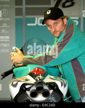 Der ehemalige Superbike-Weltmeister und Foggy Petronas Teambesitzer Carl Fogarty lehnt sich während eines freien Trainings vor der Superbike-Weltmeisterschaft am Sonntag in Silverstone auf eines seiner Fahrräder in seiner Boxengarage. Stockfoto