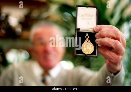 Johnny Dixon, ehemaliger Aston Villa-Spieler, hält seine Gewinner hoch Medaille aus dem FA Cup Finale 1957 Stockfoto