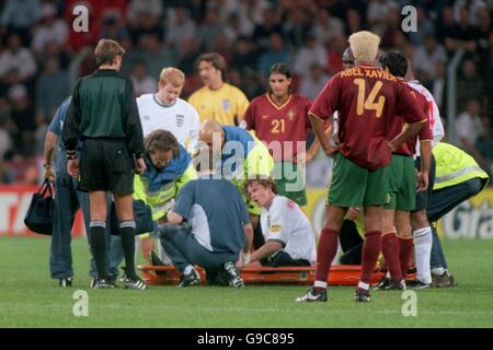 Der englische Steve McManaman liegt verletzt auf der Bahre Stockfoto