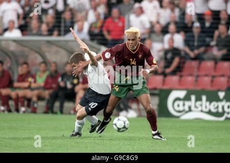 Der englische Michael Owen (l) sucht nach einem Foul wie er Wird vom portugiesischen Abel Xavier beiseite geschoben (r) Stockfoto