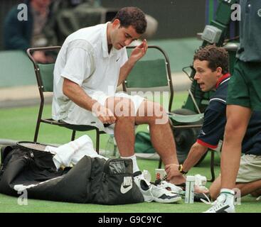 Tennis - Wimbledon Championships - Zweite Runde. Pete Sampras lässt seinen linken Knöchel von einem Physio untersuchen, nachdem er ihn stark verstaucht hat und nach dem Spiel eine Röntgenaufnahme benötigt Stockfoto