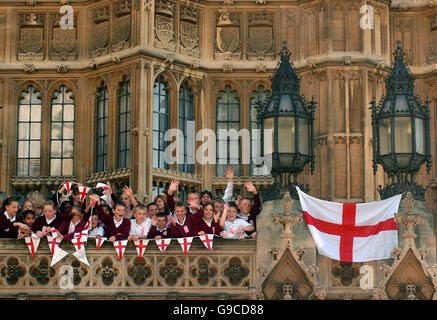 Kinder von Christchurch School in London helfen, um einer der zwei Flaggen von England von einem Balkon im House Of Lords im Zentrum von London zu hängen. Stockfoto