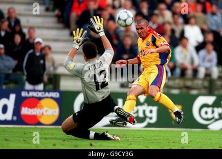 Fußball - Euro 2000 - Viertelfinale - Italien gegen Rumänien. Der Rumäne Gheorghe Hagi (r) schiebt den Ball über den italienischen Torhüter Francesco Toldo (l), nur um zu sehen, wie sein Schuss auf den Posten traf Stockfoto