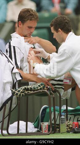 Tennis - Wimbledon Championships - Viertelfinale. Jan-Michael Gambill wird von einem Physio behandelt, nachdem er seine Brust verletzt hat Stockfoto