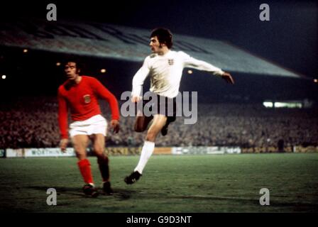 Der englische Kevin Keegan (r), der sein internationales Debüt gibt, schießt in einem Schuss hinter dem walisischen Mike England (l) Stockfoto