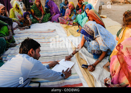 INDIEN, Madhya Pradesh, Mikrokredit, ländliche Frau Sparbank im Dorf, Analphabeten ungebildeten Adivasi Frauen unterzeichnen mit Daumen drucken für ihre Ersparnisse, Frauen Empowerment, Bhil Stamm, ST geplante Stamm Stockfoto