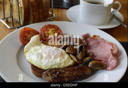 Komplettes warmes Frühstück mit Speck, Wurst, Pilzen und Tomaten Stockfoto