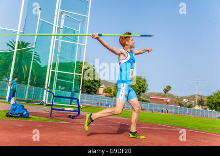 Junge Sportler wirft Speer auf einen sportlichen piste Stockfoto