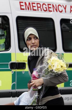 Eine nicht identifizierte Frau bringt Blumen mit als Mitglieder der Öffentlichkeit, Familie und Freunde sich an der U-Bahn-Station Edgware Road versammeln, um denen, die ihr Leben bei den Terroranschlägen an diesem Tag im vergangenen Jahr verloren haben, ihren Respekt zu erweisen. Stockfoto