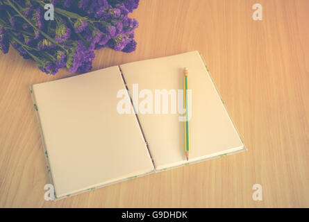 Handgemachte Buch mit Bleistift und Statice Blume auf Holztisch, Vintage-Stil Stockfoto