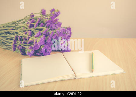 Handgemachte Buch mit Bleistift und Statice Blume auf Holztisch, Vintage-Stil Stockfoto