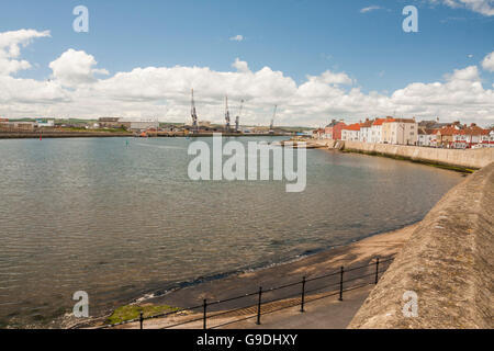 Ein Blick auf die Landzunge bei Hartlepool im Nordosten Englands zeigt Häuser, Strand und Werft Krane Stockfoto