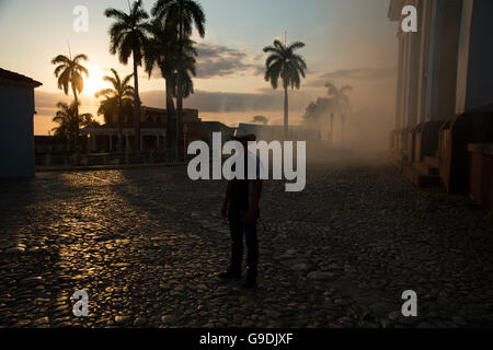 Eine kubanische Mann mit dem Cowboyhut steht in einer Wolke von moskito Insektizid bei Sonnenuntergang auf der Plaza Mayor Trinidad Kuba Stockfoto