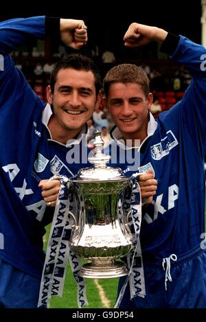 (l-r) vor einem prominenten Fußballspiel in Walsall posieren die TV-Stars will Mellor (Hollyoaks and Dream Team) und Philip Olivier (Brookside) mit dem vom AXA gesponserten FA Cup Stockfoto