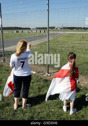 England-Fans beobachten durch den Sicherheitszaun am Stansted Airport, wie das Flugzeug, das die England-Mannschaft trägt, aus Deutschland zurückkommt. Bilddatum: Sonntag, 2. Juli 2006. England verlor 3-1 in einem Elfmeterschießen gegen Portugal während der FIFA Fußball-Weltmeisterschaft Viertelfinale am Samstag. Siehe PA Story WORLDCUP England. Bildnachweis sollte lauten: David Davies/PA. Stockfoto