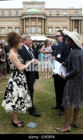 Hollywood-Regisseur Tim Burton (Brille) und seine Frau Helena Bonham-Carter (schwarz-weißes Kleid) in den Gärten des Buckingham Palace, wo sie an einer königlichen Gartenparty teilnahmen, um den 50. Jahrestag des Duke of Edinburgh Award-Programms zu feiern. Stockfoto