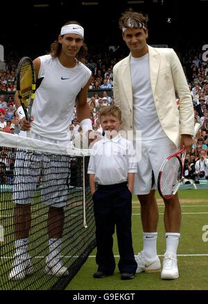 William Caines, sieben Jahre alt, aus Beckenham, Kent, vertritt Cancer Research UK, posiert mit dem Schweizer Roger Federer (rechts) und dem spanischen Rafael Nadal (links), nachdem er den Münzwurf vor dem Finale der Männer-Singles bei den All England Lawn Tennis Championships in Wimbledon gemacht hat. Stockfoto