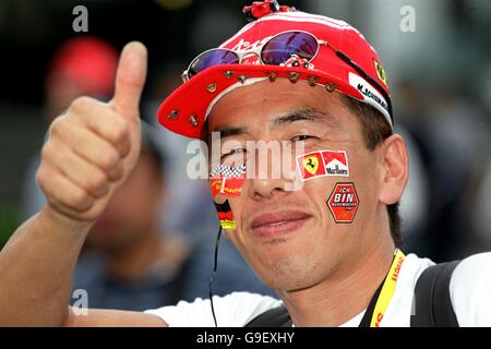 Ein japanischer Michael Schumacher Fan trägt eine Kappe mit Miniatur Ferraris an die Krempe geschraubt Stockfoto