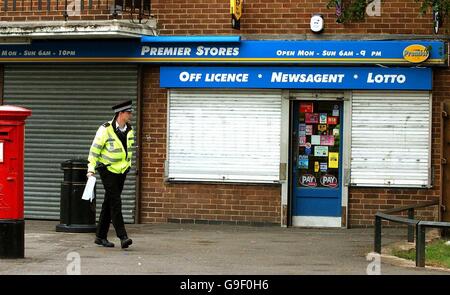 Ein Polizist kommt gestern Abend an der Szene vor einem Zeitungskiosks in der Mount Pleasant Road, Bedworth, in der Nähe von Coventry vorbei, wo ein Kollege bei einem Raub schwere Verletzungen erlitten hat. Stockfoto