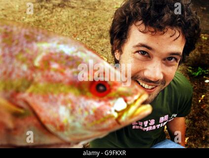 Ben Fillmore, 24 Jahre alt, aus Wood Green im Norden Londons, wird einem Pacific Red Snapper vorgestellt, der sich darauf vorbereitet, von jedem, der das höchste Gebot für E-Bay abgibt, für wohltätige Zwecke geschlagen zu werden. Stockfoto