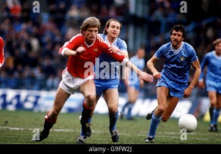 Fußball - Football League Division One - Manchester City / Manchester United. Gordon McQueen von Manchester United (l) kommt von Dennis Tueart von Manchester City (c) und David Cross (r) Stockfoto